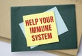 Yellow paper with word HELP YOUR IMMUNE SYSTEM on white desk