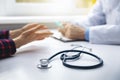 Medical consultation - doctor talking to patient in clinic office