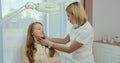 Medical cosmetologist checking female customer. Cosmetologist in white gloves examining face skin of young female client