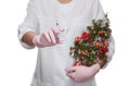 The medical cosmetologist holds a syringe for injection and a small decorated Christmas tree in the beauty salon.