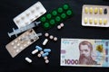 Medical costs during coronavirus crisis. Epidemic covid-19 concept in Ukraine. Hryvnia banknotes and pills