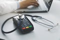 medical costs and health care expenses concept - payment terminal with stethoscope on the table Royalty Free Stock Photo