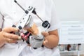 Dentist holding dental articulator with dental gypsum prosthesis model in dental laboratory