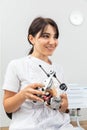 Dentist holding dental articulator with dental gypsum prosthesis model in dental laboratory