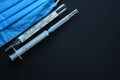 Medical devices. Protective surgery blue mask, syringe and thermometer on a black background. Copy space Royalty Free Stock Photo