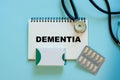 Medical diagnosis - Dementia. Medicine concept. Doctor`s desk with notepad, pills in capsules and stethoscope