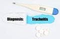 Medical diagnosis. On paper a thermometer, pills and a hole, inside which the inscription - Tracheitis