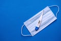 Medical digital thermometer and medical mask on a blue background. Medical header layout