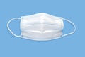 Medical disposable surgical mask on a blue monochrome background. Protection against infections, viruses and bacteria. Royalty Free Stock Photo