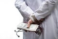 Medical doctor holding money and stethoscope in hospital setting Royalty Free Stock Photo