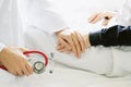 Medical doctor holding patient`s hands and comforting her with care.