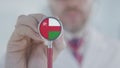 Medical doctor holds stethoscope bell with the Omani flag. Healthcare in Oman