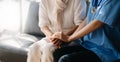 Medical doctor holing senior patient`s hands and comforting her at home Royalty Free Stock Photo