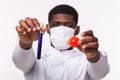 Medical doctor or laborant holding tube with Coronavirus vaccine for COVID-19. Coronavirus model in human hand. Vaccine