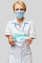 Medical doctor nurse woman with stethoscope - holding protective mask and sanitizer