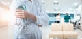 Medical doctor standing with stethoscope and arm crossed posing on health examination patient room background, close up of Royalty Free Stock Photo