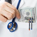 Medical doctor with US dollars in his pocket - close up Royalty Free Stock Photo