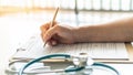 Medical doctor writing on patient personal health care record discharge form, or prescription paperwork in hospital Royalty Free Stock Photo