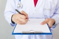 Medical doctor writing prescription on white isolated background Focus on clipboard. Royalty Free Stock Photo