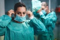 Medical doctors and nurse preparing for surgical operation in hospital during coronavirus outbreak - Focus on right man Royalty Free Stock Photo