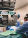 Medical drug infusion pumps in the foreground with 2 surgeons operating in the background selective focus - scene from operatin