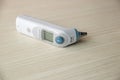 medical ear thermometer isolated on wooden table. Digital thermometer for baby. Royalty Free Stock Photo