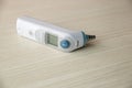 Medical ear thermometer isolated on wooden table. Digital thermometer for baby. Royalty Free Stock Photo