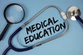 Medical Education text with Stethoscope and magnifying glass on blue background Royalty Free Stock Photo