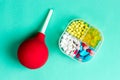 Medical enema and pill box with pills, pharmaceutical tablets, medical supplies. View from above.