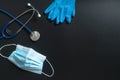 Medical equipment needed to prevent the spread of coronavirus.Surgical mask, Stethoscope, Glove on dark background.Coronavirus