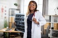 African woman gp doctor, posing to camera in her modern private office with MRI scan in hands Royalty Free Stock Photo