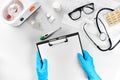 Medical equipment with stethoscope and board in doctor`s office on white desk background top view mock-up Royalty Free Stock Photo