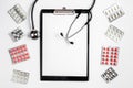 Medical equipment with stethoscope, board and pills in doctor`s office on white desk background top view mock-up Royalty Free Stock Photo