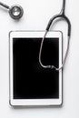 Medical equipment with stethoscope and tablet in doctor`s office on white desk background top view mock-up Royalty Free Stock Photo