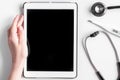 Medical equipment with stethoscope and tablet in doctor`s office on white desk background top view mock-up Royalty Free Stock Photo