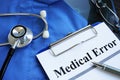 Medical error report with stethoscope and doctor robe. Royalty Free Stock Photo