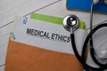 Medical Ethics text with document brown envelope and stethoscope isolated on office desk Royalty Free Stock Photo