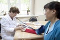 Health care, elderly and medical concept - female doctor or nurse with patient taking blood pressure