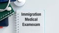 A medical exam is written on a notebook. The notebook is on a table with a stethoscope and a pen, Immigration medical exam Royalty Free Stock Photo