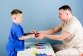 Medical examination. Medical service. Man doctor sit table medical tools examining little boy patient. Health care Royalty Free Stock Photo