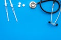 Medical examination and treatment concept. Stethoscope, syringe, pills on blue background top view copy space Royalty Free Stock Photo