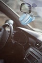 Medical face mask hanging on rear view mirror inside the car. for protect himself from bacteria and virus while driving a car Royalty Free Stock Photo