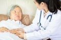 Medical female doctor or nurse holding senior patient hands and comforting her at hospital bed or home,hand of elderly woman with Royalty Free Stock Photo