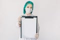 Medical female specialist, doctor or nurse, wearing medical cap and mask, showing the clipboard with blank paper to Royalty Free Stock Photo