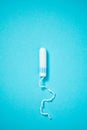Medical female tampon on a blue background with copy space. Hygienic white tampon for women. Cotton swab. Menstruation, means of Royalty Free Stock Photo