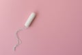 Medical female tampon on a pink background. Hygienic white tampon for women. Cotton swab. Menstruation, protection concept, flat