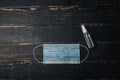 Medical gauze mask and sanitizer on black wooden background. Covid 2019, selfisolation, healthcare, disease prevention, epidemic