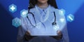 Medical genetics. Female doctor holding tablet computer with DNA helix and other medical icons above screen, collage