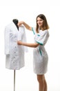 A medical gown hangs on a mannequin, a girl nurse straightens the collar of a gown Royalty Free Stock Photo