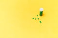 Medical green pills in a glass bottle on yellow background copyspace, health Royalty Free Stock Photo